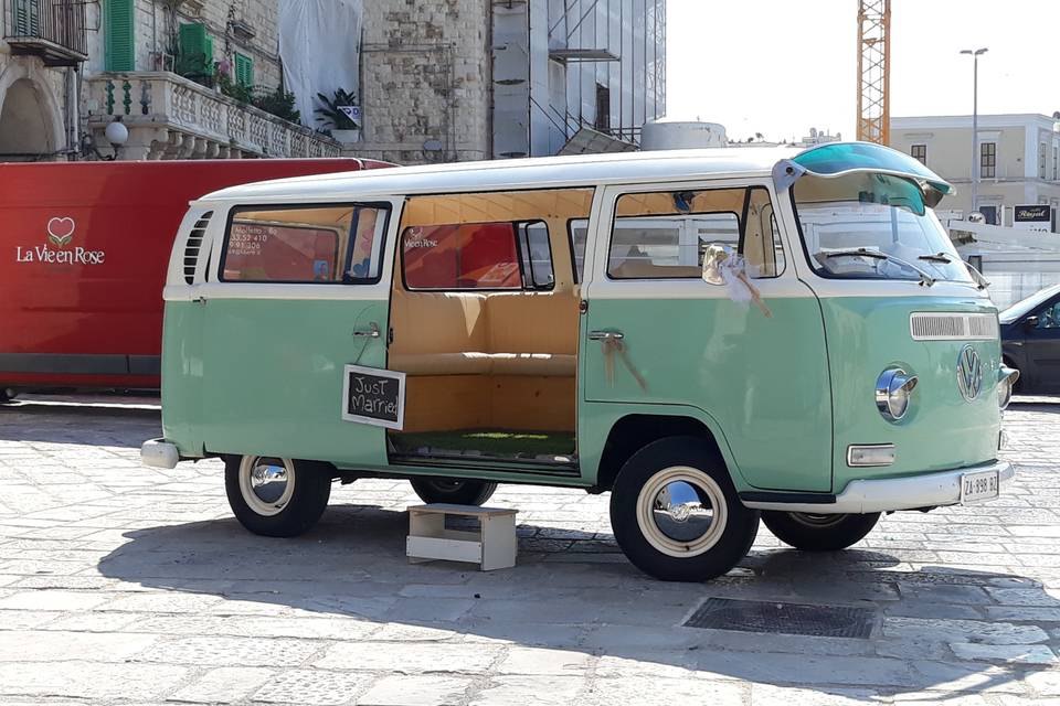 Pulmino bianco e verde con la porta laterale aperta e un cartello «Just Married»